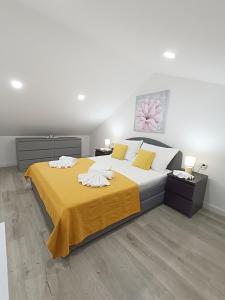 ein Schlafzimmer mit einem großen Bett und einer gelben Decke in der Unterkunft Villa Ana Marija - Family destination with heated pool in Lećevica