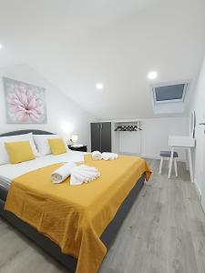 ein Schlafzimmer mit einem großen Bett mit gelber und weißer Bettwäsche in der Unterkunft Villa Ana Marija - Family destination with heated pool in Lećevica