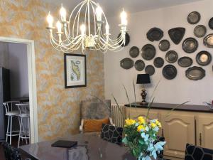 a dining room with a chandelier and plates on the wall at Le Clos des Lys, Maison de Pays Raffinée Proche de la Mer in Saint-Georges-dʼOléron +41 photos