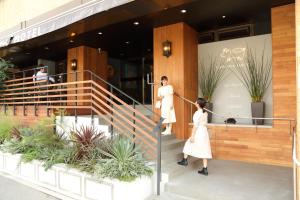 two women walking up the stairs of a building at Osaka Corona Hotel in Osaka