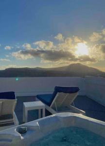 wanna z hydromasażem z krzesłami i stołem na balkonie w obiekcie Villa Solasta #2 with jacuzzi in Santorini w Akrotiri