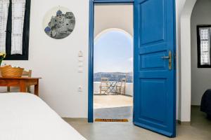 niebieskie drzwi w pokoju z łóżkiem w obiekcie Villa Solasta #2 with jacuzzi in Santorini w Akrotiri