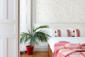 ein Schlafzimmer mit einem Bett und einer Topfpflanze in der Unterkunft San Luis Luxury House with Terrace in Sevilla