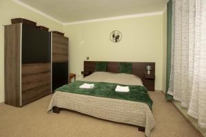 1 dormitorio con 1 cama con 2 toallas en Diófa Apartman Balatonederics, en Balatonederics