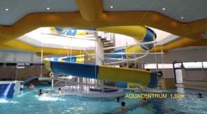 a water slide in a swimming pool with people in it at Penzion hrad Doubravka in Teplice