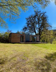 a small house sitting on top of a grass field at Kemp Pod Lipami in Dolní Bečva