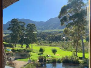 a view of a golf course with mountains in the background at The Guardian Hermanus Luxury Self-Catering Hemel en Aarde Valley in Hermanus