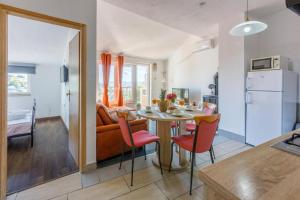 cocina y sala de estar con mesa y sillas en Apartman Franka en Crikvenica