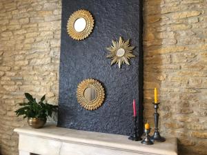 a fireplace with three mirrors on a wall at Le Clos des Lys, Maison de Pays Raffinée Proche de la Mer in Saint-Georges-dʼOléron