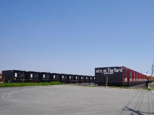Une rangée de wagons de train garés à côté d'une rue dans l'établissement HOTEL R9 The Yard Tsu, à Tsu