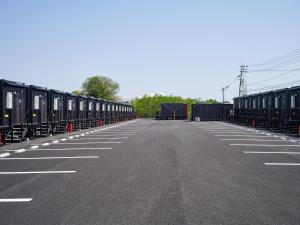 une rangée de wagons garés dans un parking dans l'établissement HOTEL R9 The Yard Tsu, à Tsu