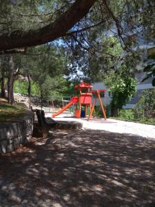 een speeltuin in een park met een rode glijbaan bij Seafoam Apartment in Rijeka