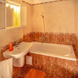 a bathroom with a white tub and a sink at Diófa Apartman Balatonederics in Balatonederics