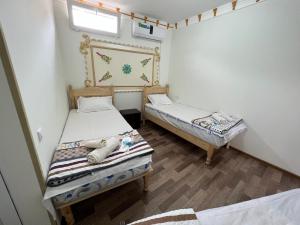 a bedroom with two beds and a mirror on the wall at Shaxruza Shahzoda Guest House in Bukhara