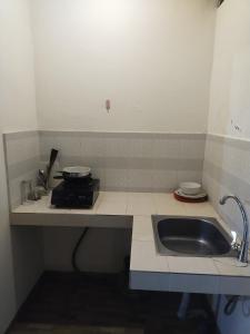 uma cozinha com um lavatório e uma bancada em ComeBack GuestHouse em Canggu
