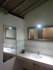 uma casa de banho com dois lavatórios e dois espelhos em ComeBack GuestHouse em Canggu