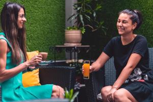 zwei Frauen, die auf Stühlen sitzen und reden und lachen in der Unterkunft Business Hotel Plovdiv in Plowdiw