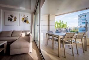 ein Wohnzimmer mit einem Tisch und einem Sofa in der Unterkunft 06 LUXURY MARINA 3 BEDROOMS in Ibiza-Stadt