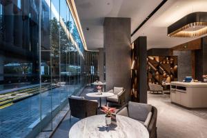 a restaurant with tables and chairs and a pool at UrCove by Hyatt Shanghai Lujiazui Expo Center in Shanghai