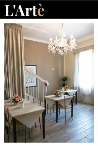 a dining room with two tables and a chandelier at L'artè in Cascina