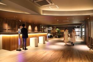un grupo de personas de pie en un vestíbulo en Osaka Corona Hotel en Osaka