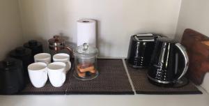 encimera de cocina con tazas de café y cafetera en Maddisons Garden Guest Suite - Coatesville, en Albany