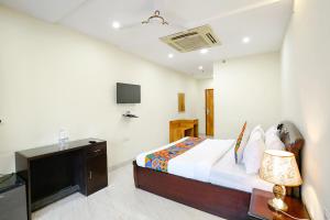 a bedroom with a bed with a television and a desk at FabHotel F9 NSP in New Delhi