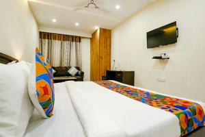 a hotel room with a bed and a tv at FabHotel F9 NSP in New Delhi