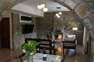 a living room with a stone wall and a fireplace at Mountain House Perampela in Nofaliás