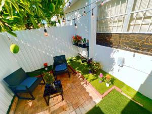 a patio with two chairs and a lawn with plants at Miami Gardens Comfort Suite by Hard Rock Stadium in Miami Gardens