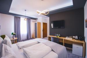 a bedroom with a bed and a desk with a tv at Rabbit Hole Superior Extension in Sibiu