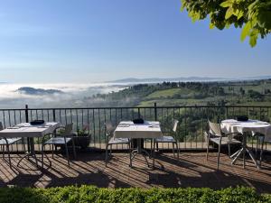 due tavoli e sedie su un balcone con vista di Terra d'Ombra Bed&Breakfast a San Gimignano