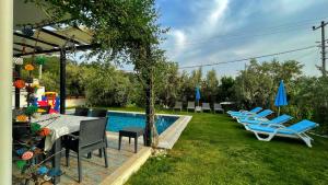 um quintal com uma piscina com cadeiras e uma mesa em Private Villa in Gocek Villa Perest em Göcek