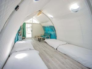 ein Zimmer mit 2 Betten und einem Stuhl darin in der Unterkunft GLAMTECH RESORTS HEAVEN in Miyako-jima