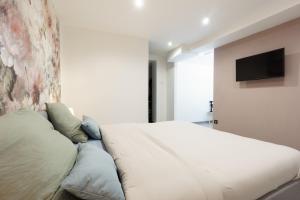 a bedroom with a large bed and a flat screen tv at Romance O'Berry in Châteauroux