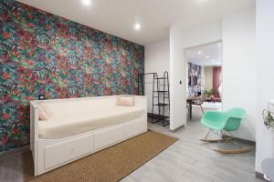 a bedroom with a white bed and a colorful wall at Romance O'Berry in Châteauroux