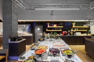 a table with bowls of food on it in a kitchen at Comfort Hotel LT - Rock 'n' Roll Vilnius in Vilnius