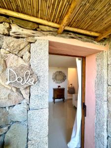 Villa Kalypso - Porto Cervo في بورتو كيرفو: مدخل لمنزل بجدار حجري