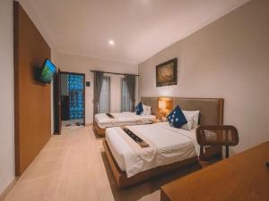 a hotel room with two beds and a table at Perissos Echo Beach in Canggu