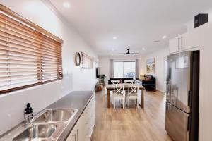 a kitchen and living room with a sink and a refrigerator at Two Rivers - Harriet in Kingscote +24 photos