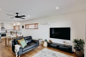 a living room with a couch and a flat screen tv at Two Rivers - Harriet in Kingscote