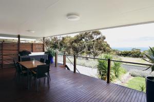a house with a balcony with a table and chairs at Two Rivers - Harriet in Kingscote