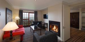 - un salon avec une cheminée et un canapé rouge dans l'établissement The Caledon Hotel and Spa, à Caledon