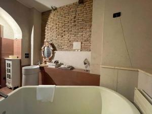 ein Badezimmer mit einer weißen Badewanne und einer Ziegelwand in der Unterkunft Fornace Garitta in Albissola Marina