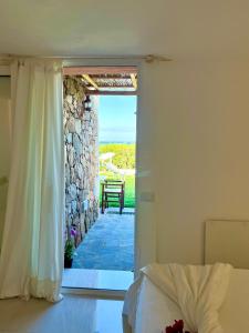 Villa Kalypso - Porto Cervo في بورتو كيرفو: غرفة نوم مع باب مفتوح على الفناء