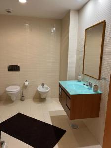 een badkamer met een wastafel en een toilet bij Olhão Marina Village in Olhão