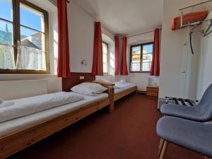 two beds in a room with red curtains at Garni Hotel Zum Hothertor in Görlitz