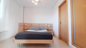 ein Schlafzimmer mit einem Bett mit blauen Kissen in der Unterkunft Ayf 3 habitaciones moderno 1ª linea de playa in Oropesa del Mar
