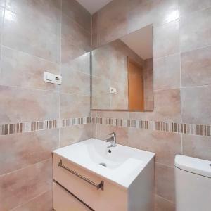 ein Badezimmer mit einem Waschbecken, einem Spiegel und einem WC in der Unterkunft Ayf 3 habitaciones moderno 1ª linea de playa in Oropesa del Mar