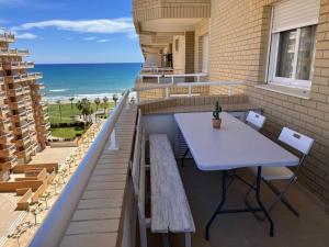 einen Tisch und Stühle auf einem Balkon mit Strandblick in der Unterkunft Ayf 3 habitaciones moderno 1ª linea de playa in Oropesa del Mar